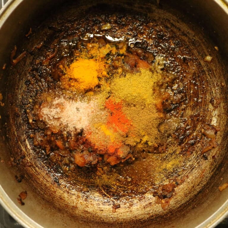 手順 7: トマトの水分が飛んだら、スパイスBと塩を加え、全体的にねっとりするまで炒めます。ここで味が決まるので、ヘラを動かしても水