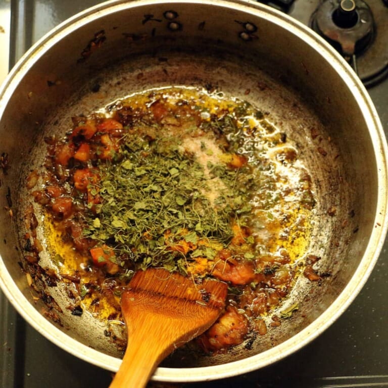 手順 5: 玉ねぎが飴色になったらトマトを加え、次にスパイスB、塩を加え炒めます。