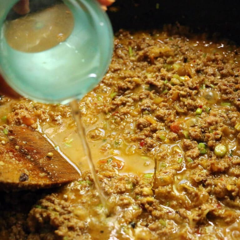 手順 7: ひき肉に火が通ったら水を加え約15分蓋をして煮込みます。