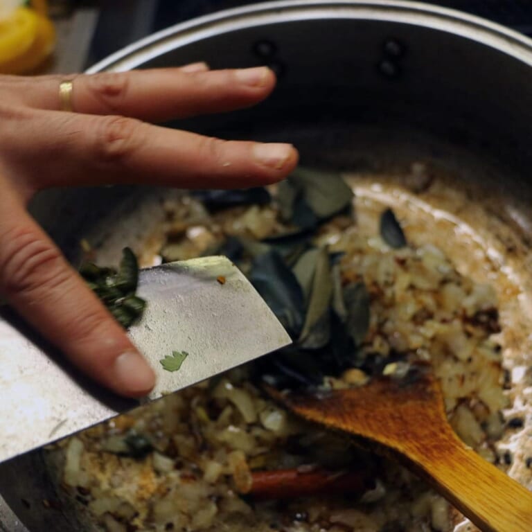 手順 2: 玉ねぎがあめ色になったらにんにく、生姜、青唐辛子、カレーリーフを加えて炒めます。