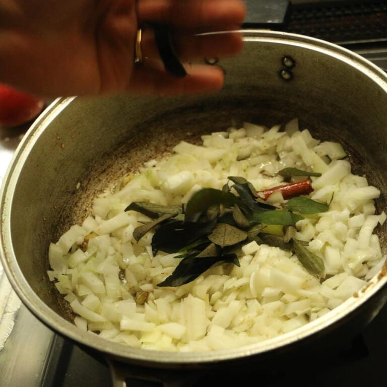 手順 5: 玉ねぎが黄色くなる前に、カレーリーフを加えて炒めます。
