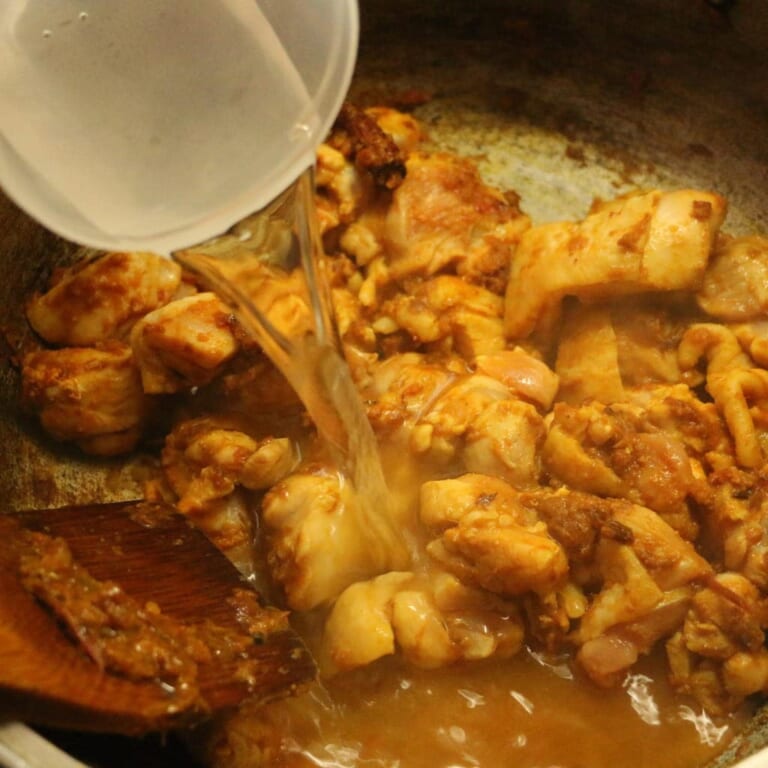 手順 3: 鶏もも肉の表面に火が入ったら少しずつ水を加え、煮込み煮立ったら弱火にして5分に煮込みます。