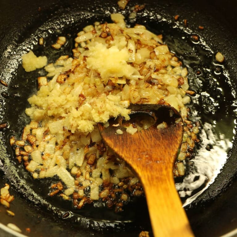 手順 3: 玉ねぎがあめ色になったら、にんにく、生姜を加えます。
