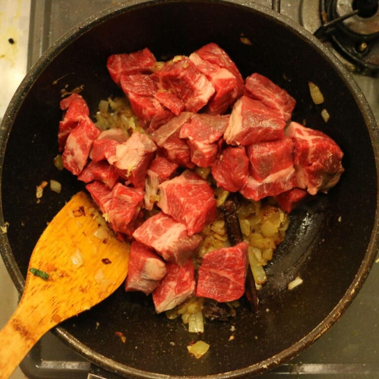手順 4: カルダモンが膨らんだら玉ねぎを加え飴色になるまで炒める。 おろしにんにく・ショウガを加えて、続いて牛肉を加えてしっかりと