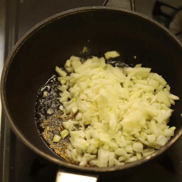 手順 1: 温めたフライパンに油を入れスパイスAを加え、香りが立ってきたら玉ねぎを加える。