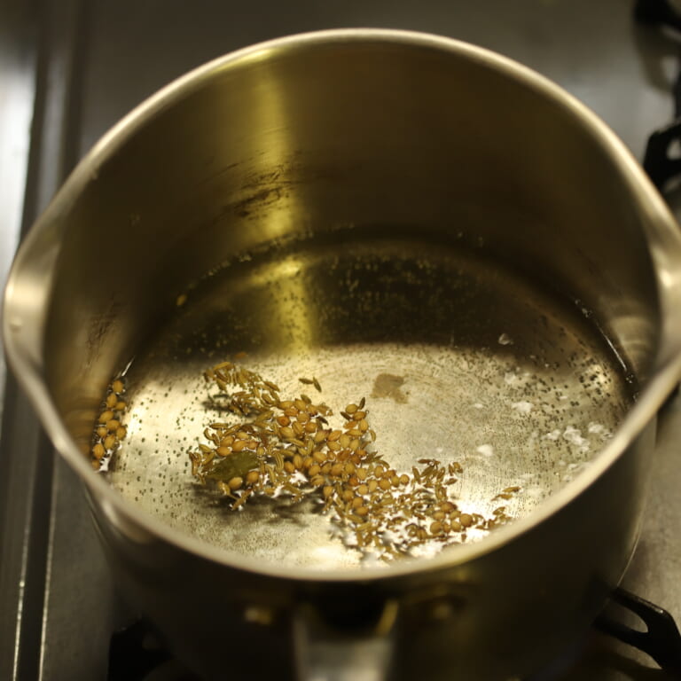 手順 1: 鍋に水、生姜（スライス）、スパイスを加え火にかけ沸騰したら火を弱める。