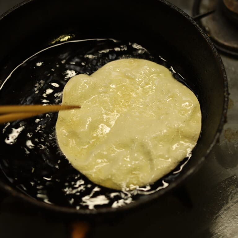 手順 1: 温めた油にパパドを1枚ずつさっとくぐらせる。