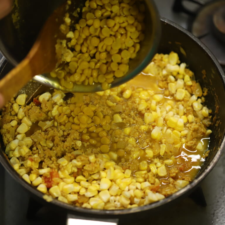 手順 8: 鶏ひき肉に火が通ったら茹でておいたチャナダール、トウモロコシを加え蓋をして弱火にして約5分煮こむ(必要であったら水(分量