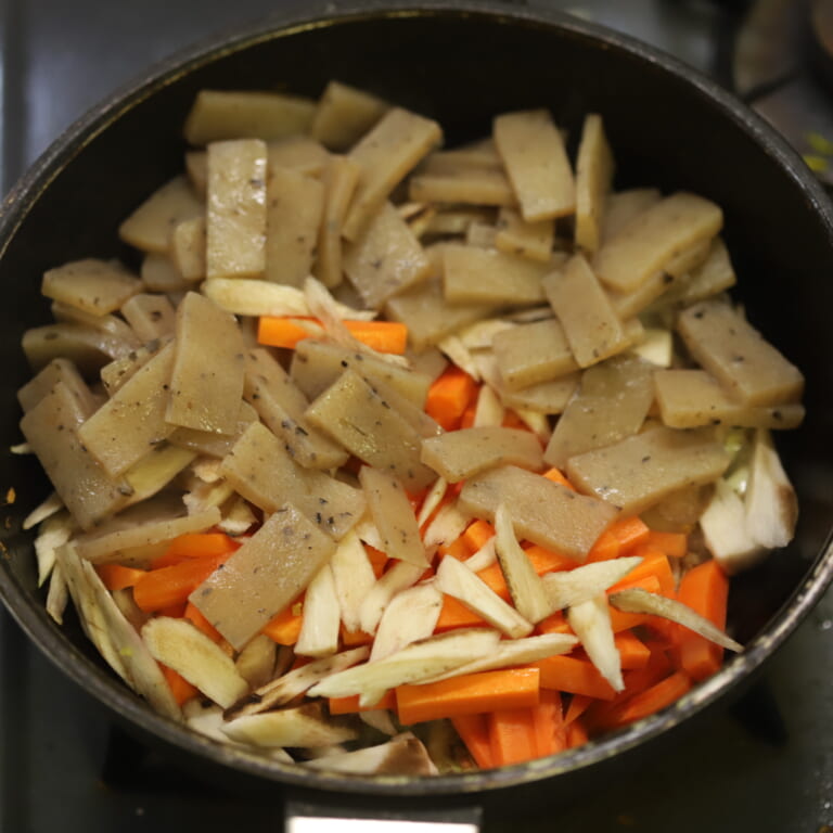 手順 3: ごぼう、人参、こんにゃくも加え焼き目がつくように炒める。