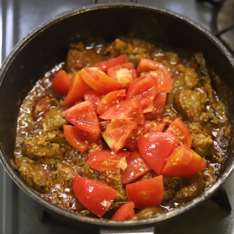 手順 3: トマトを加えなじませ、少しずつ水を加えラム肉がしっかりと柔らかくなるまで煮込む。