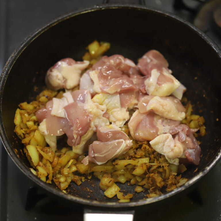 手順 3: にんにく・生姜の香りが馴染んできたらスパイスBと塩を加え炒め、鶏もも肉を加える。