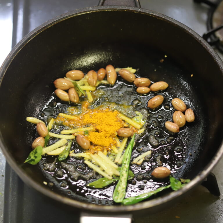 手順 2: 温めたフライパンに油をひき、スパイスA、青唐辛子、生姜、ピーナッツを炒めて香ばしい香りが立ってきたらスパイスBを加え油に