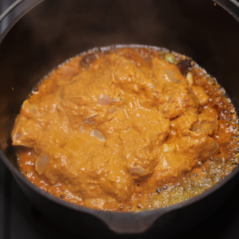 手順 7: マリネしておいた鶏もも肉をマリネ液ごと加え、鶏もも肉の表面に火が入ったらきのこ類とトマトを加え煮込む。