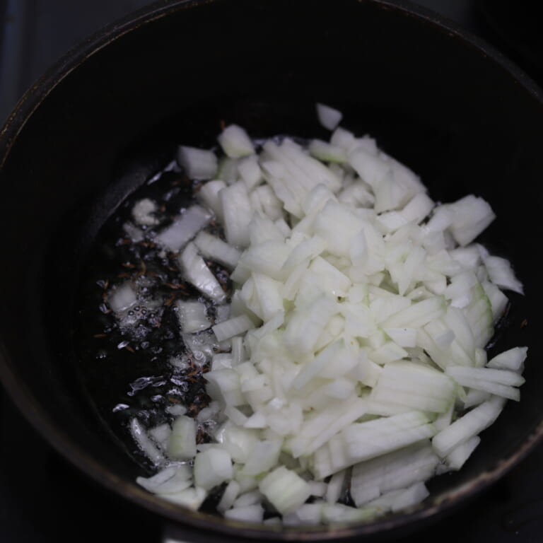 手順 4: 温めたフライパンに油を入れ、玉ねぎが透明になるまで炒める。