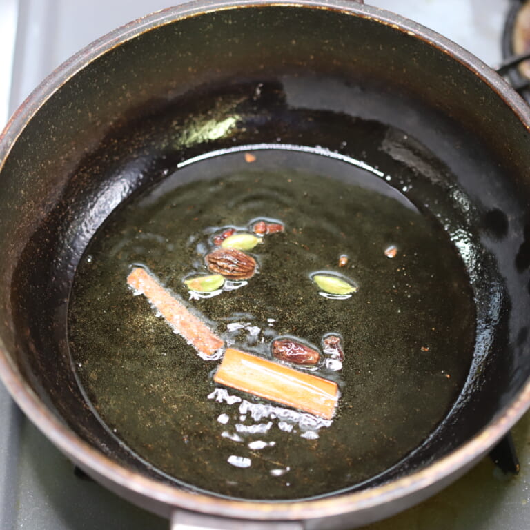 手順 3: 温めたフライパンにギーを加えスパイスAを熱する。