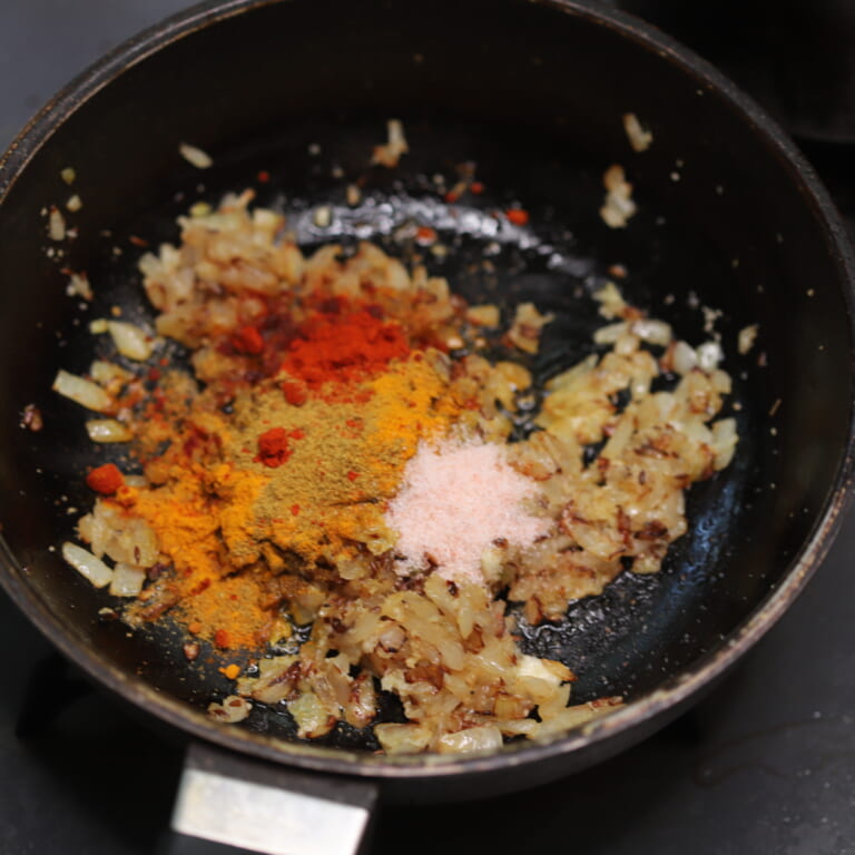手順 3: おろしにんにく・生姜を加え香りが立ってきたらスパイスBと塩を加え鳥もも肉を炒める。