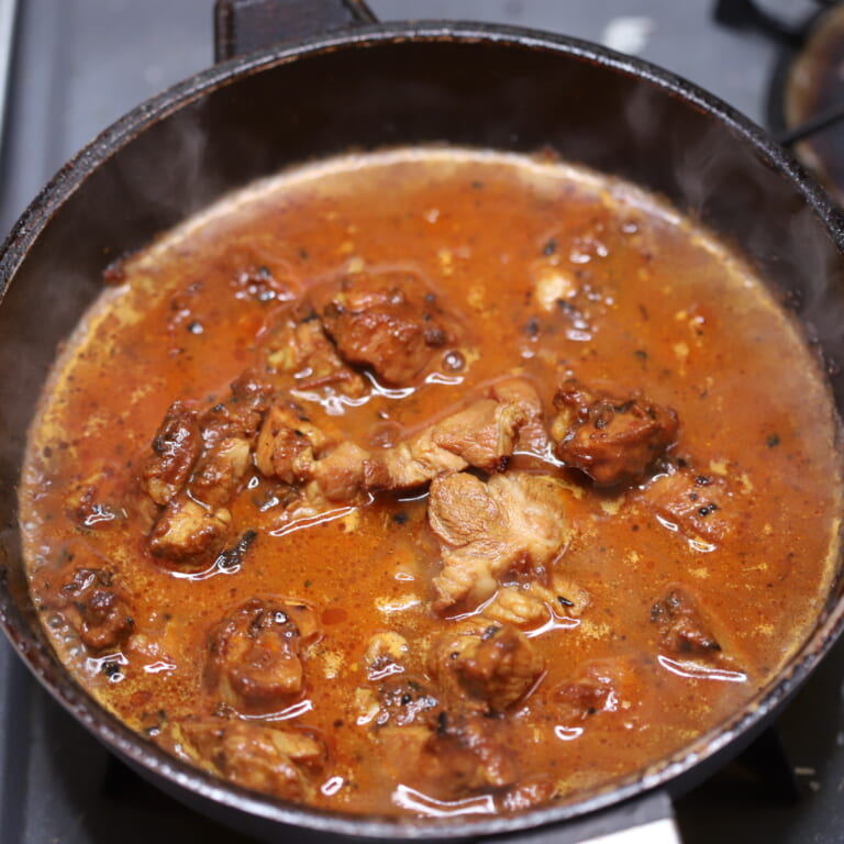 手順 5: 豚肉に火が通ってきたら少しずつ水を加えグツグツとしてきたら弱火にかえ蓋をして約10分煮込む。