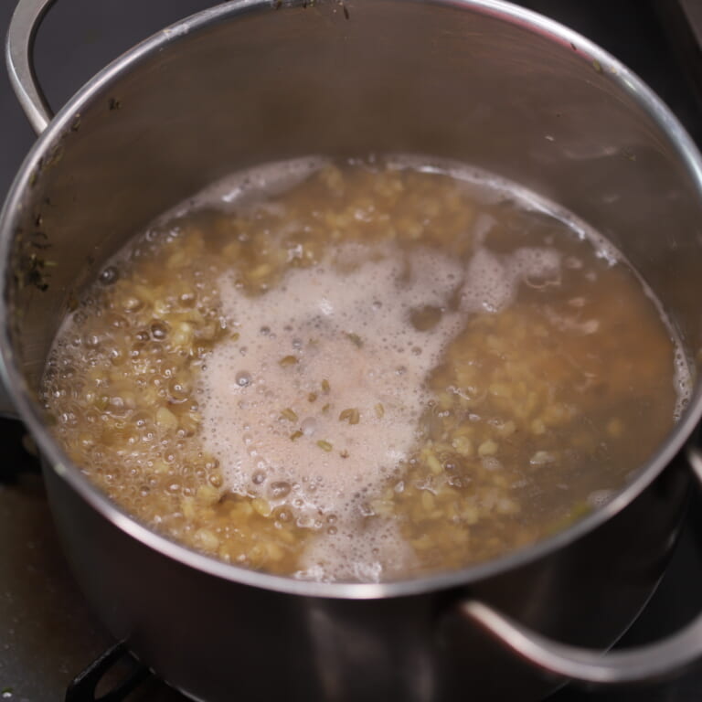 手順 1: ムングダール（殻付き）を洗い水（分量外）に約30分ほどつけておく。その後、鍋にムングダール、水を加え柔らかくなるまで煮込