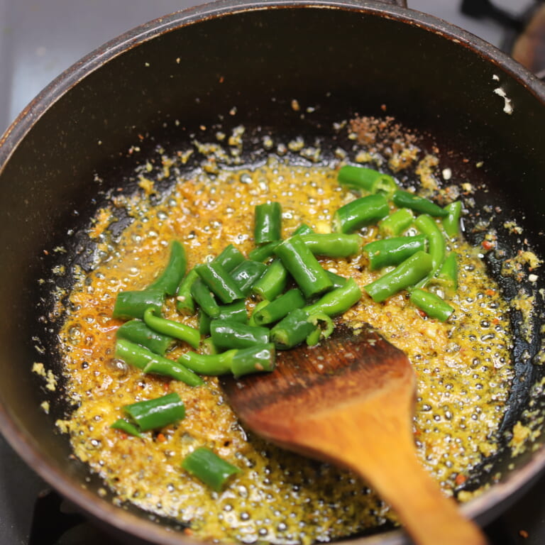 手順 2: おろしにんにく・生姜を加える。余熱で香りが立ってきたら、スパイスB、塩、青唐辛子を入れ再び火を通す。
