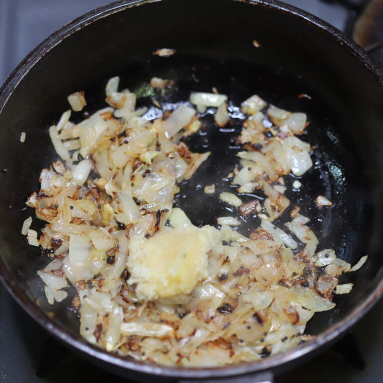 手順 2: パチパチとしてきたら玉ねぎを加え飴色になるまで炒めおろしにんにく・生姜を加える。