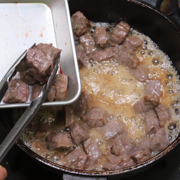 手順 2: 温めたフライパンに油を熱し角切りにした牛肉を焼いておく。お好みで塩・胡椒などしてもOK