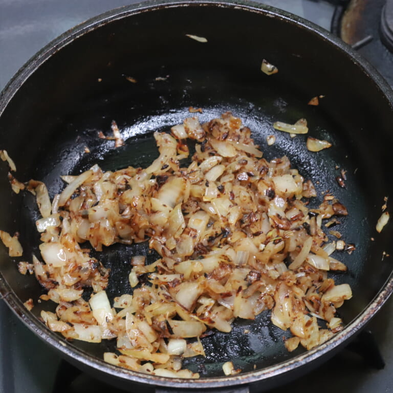 手順 1: 温めたフライパンに油を加えアジョワン（スパイスA）を熱し、しゅわしゅわとしてきたら玉ねぎを加え飴色になるまで炒める。