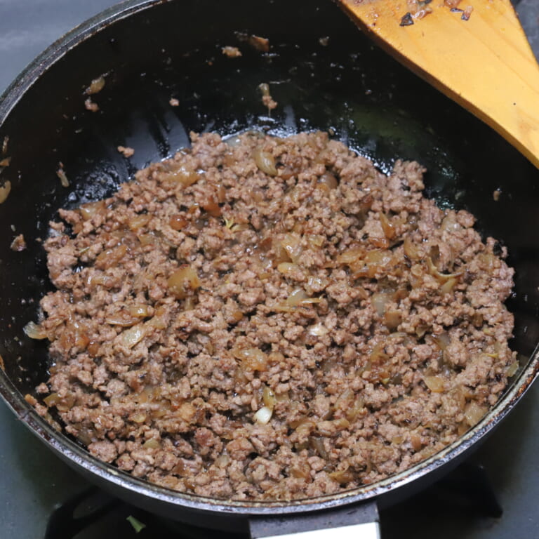 手順 2: おろしにんにく・生姜を加え香りが立ってきたら合いびき肉を加えしっかりと炒める。