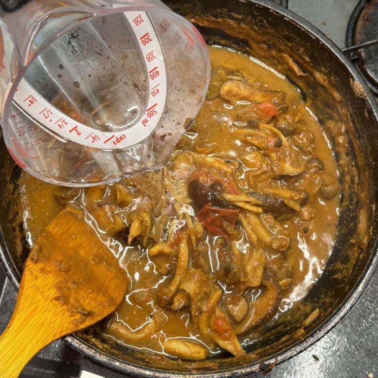 手順 5: 油が浮いてきたら水を少しずつ加えグツグツしてきたら弱火に変え４、５分蓋をして煮込む。