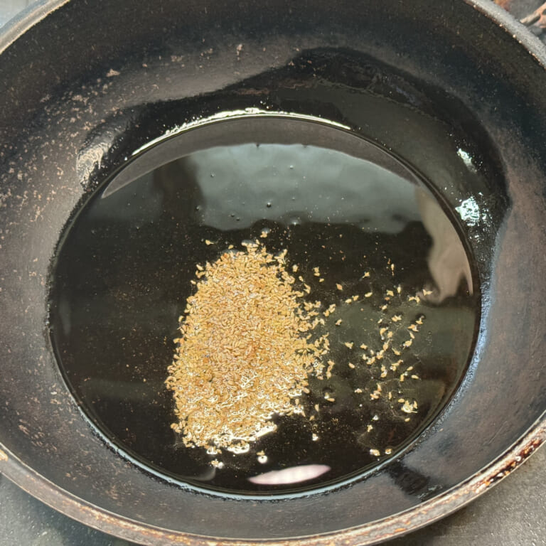手順 1: 温めたフライパンに油（ギー）を加えスパイスAを熱する。