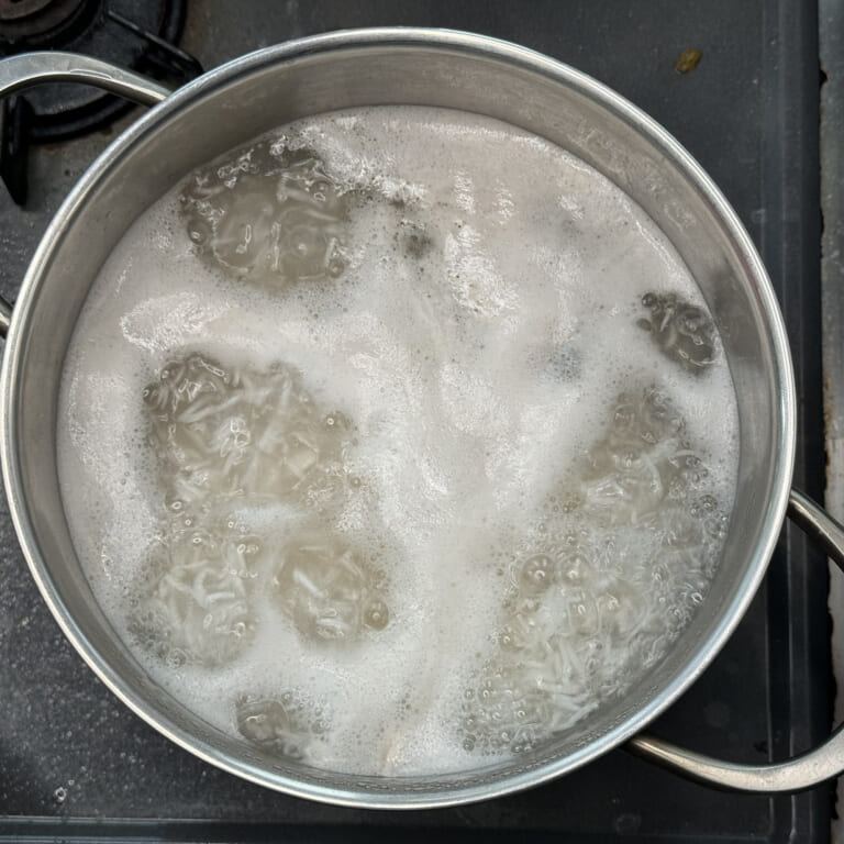 手順 1: バスマティライスを軽く洗い30分浸水しておき、 油大さじ1、塩小さじ1とともにたっぷりの水で茹でる。5,6分茹でてお米が