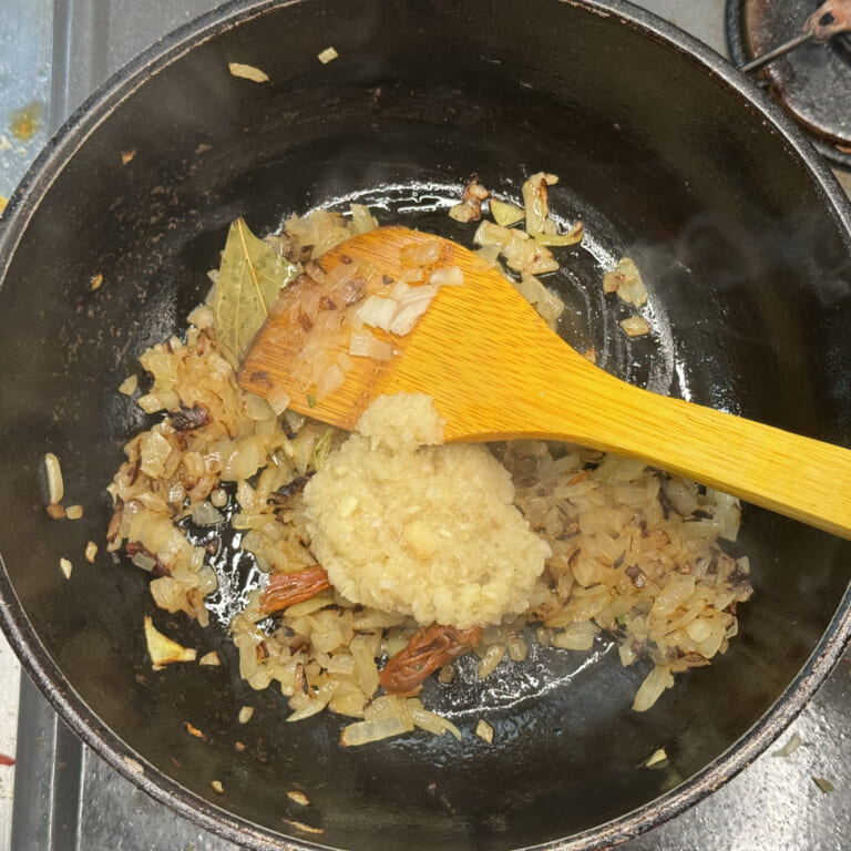 手順 2: 温めたフライパンにギー（油）を加えスパイスAを熱する。 香りが立ってきたら玉ねぎを飴色になるまで炒め、おろしにんにく、生