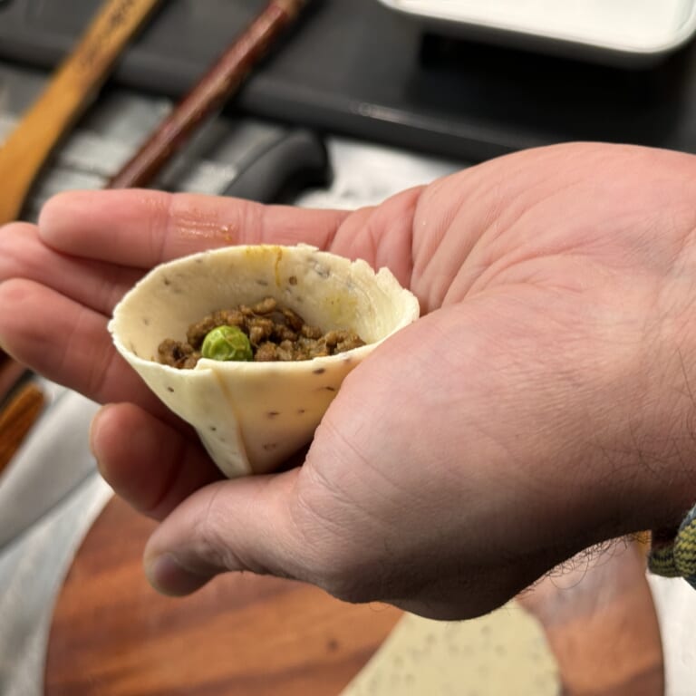 手順 7: 切った断面を合わせるように円錐状の筒を作り、閉まる程度の具材を詰めて蓋をする。