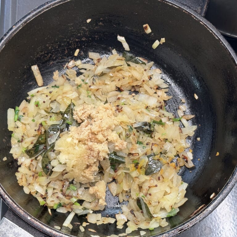 手順 4: 玉ねぎが薄い飴色になったらおろしにんにく・生姜を加える。