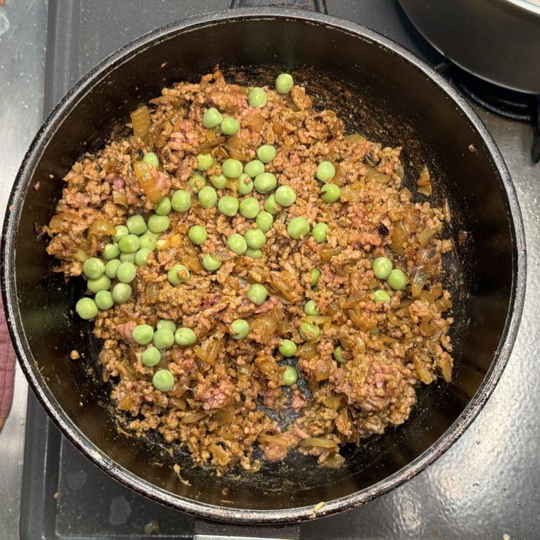 手順 5: スパイスCと塩を加え炒め合わせたら、合いびき肉を加えしっかりと火が通るまで炒める。グリーンピースを加え蓋をし、弱火で火が