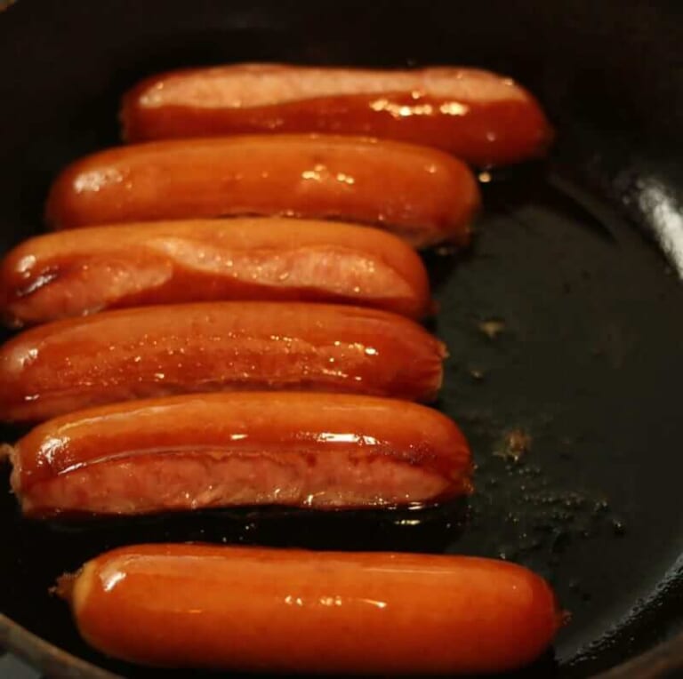 手順 2: 温めたフライパンに油をいれソーセージを焼き、お皿に盛りつけてケチャップをまぶし、ローストしたカレー粉をふりかけます。