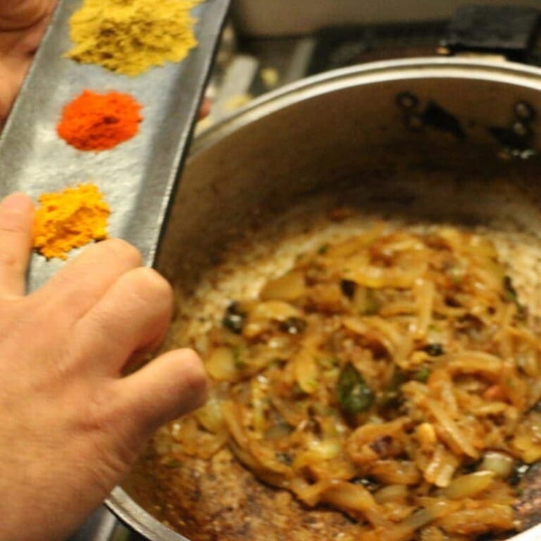 手順 5: しっかりと水分が飛んだら、スパイスB、塩を加え軽く炒めたらイカ、トマトを加える。