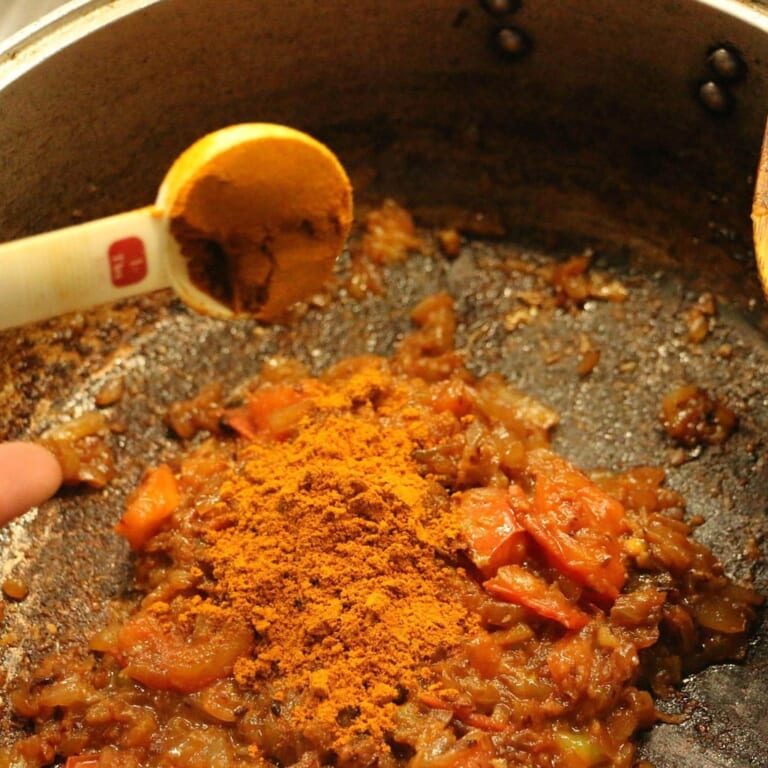 手順 4: スパイスB、塩、鶏肉を加えたあとに、少しずつ水を加える。