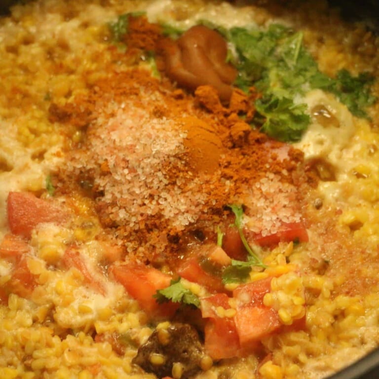 手順 2: 鍋につけておいた豆を入れトマト、パクチー、スパイスB、塩、黒糖、梅干し、水を加え、中火で煮込む。
