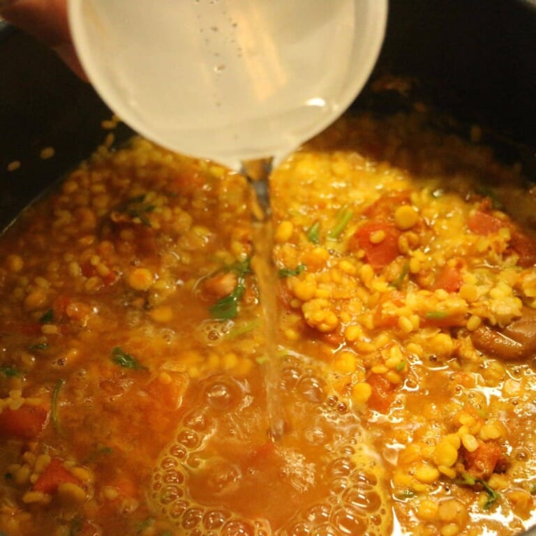 手順 3: ぐつぐついってきたら、弱火にして豆がとろとろになるまで煮込む。 （水を適宜足す（分量外））