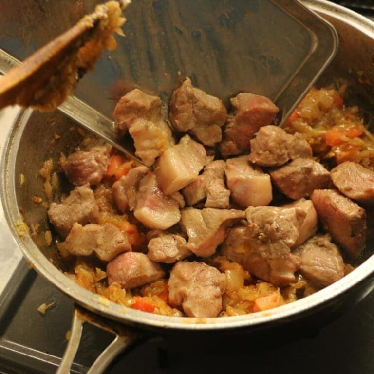 手順 6: 取り出した豚肉を加え馴染ませ人参、ジャガイモの順に加え炒め、水で少しずつ伸ばして行く。