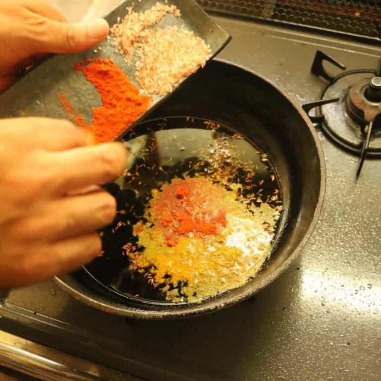 手順 3: パウダースパイスが焦げない程度油の温度が下がったらパウダースパイスと塩を加える。