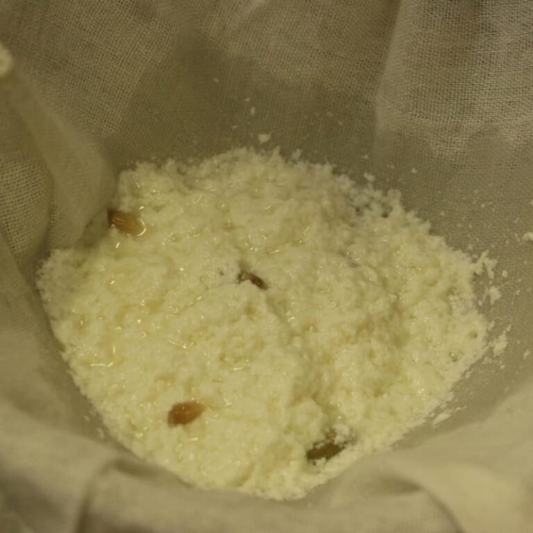 手順 3: 分離したらガーゼのような布を使い、こします。 布に残ったものを軽く絞り、冷蔵庫に重しをおいて入れておきます。(約30分)