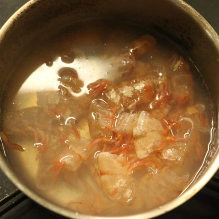 手順 1: エビの背わたをとっておく。エビの皮で水を一緒に煮込んで出汁100mlを作っておく。