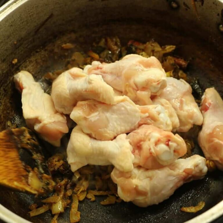 手順 5: 手羽元を入れ色が変わるまで炒め、トマトを加えて混ぜ合わせます。