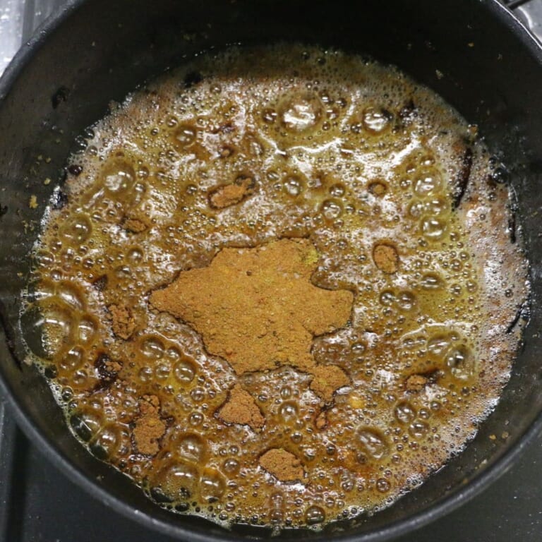 手順 4: フライドオニオンを作った油を温め、にんにく、生姜を加え炒める。 にんにく、生姜の色が飴色に変わったらガラムマサラ以外のパ