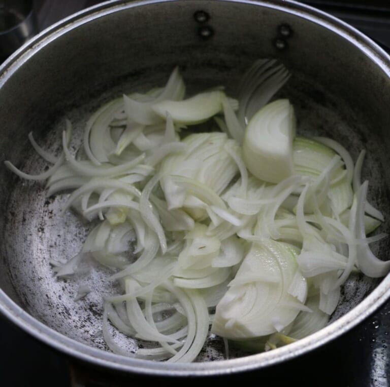 手順 1: 温めたフライパンに油をひき、玉ねぎを炒める。