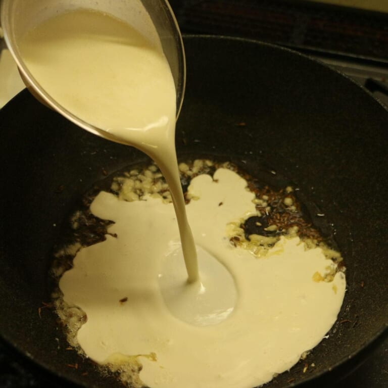 手順 7: にんにくの香りが立ってきたら生クリームを加える。
