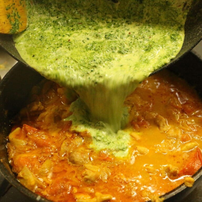 手順 8: 鶏もも肉が入った鍋にほうれん草のペーストを加えて煮込む。