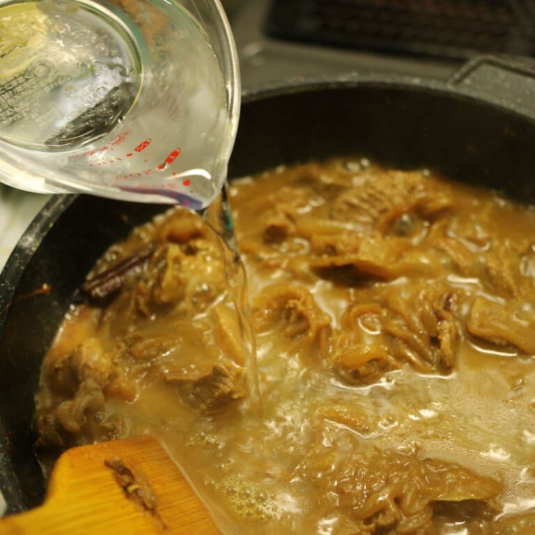 手順 6: 牛肉の表面に火が通ったら水を少しずつ加え煮込む。