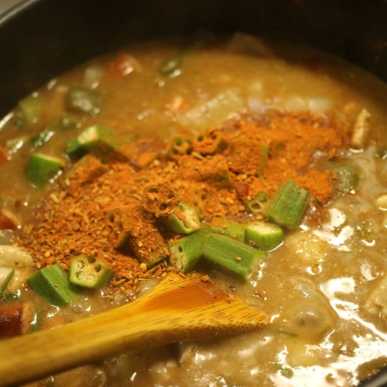 手順 7: 馴染んだらオクラ、ケイジャンスパイスを加えて煮込む。必要であれば塩で味を整える。